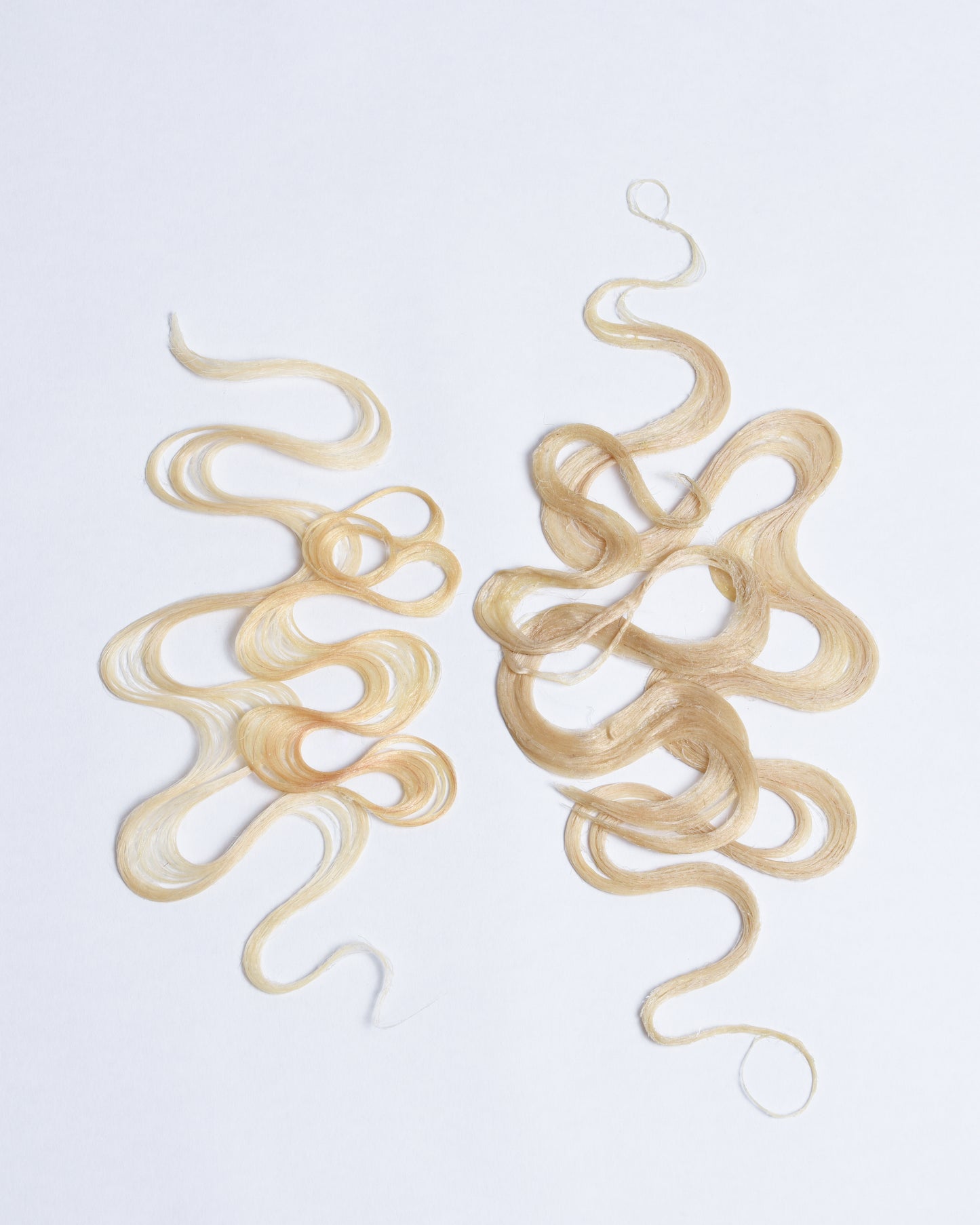 Blonde synthetic and human hair styled like finger waves moving in different directions