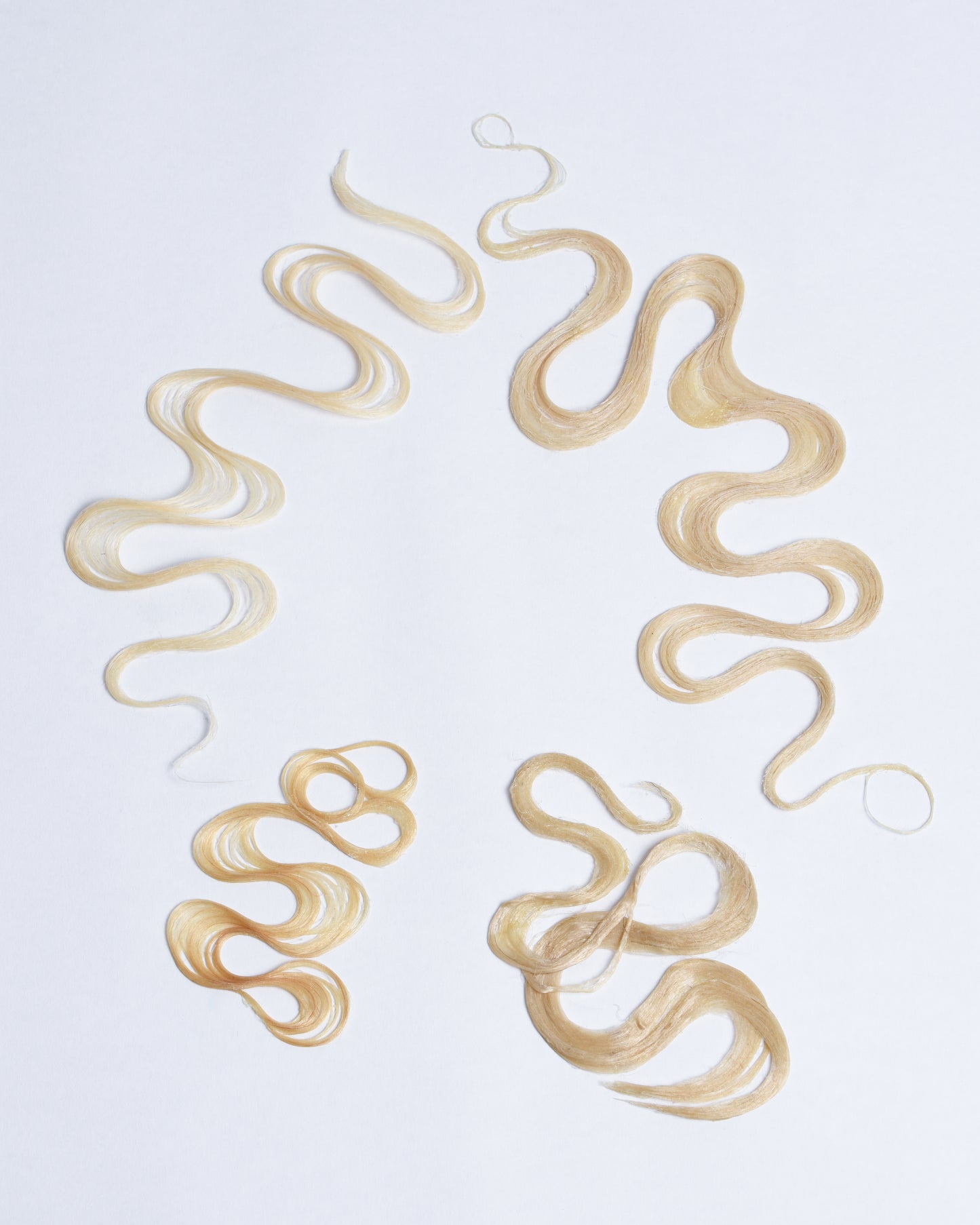 Blonde synthetic and human hair styled like finger waves moving in different directions