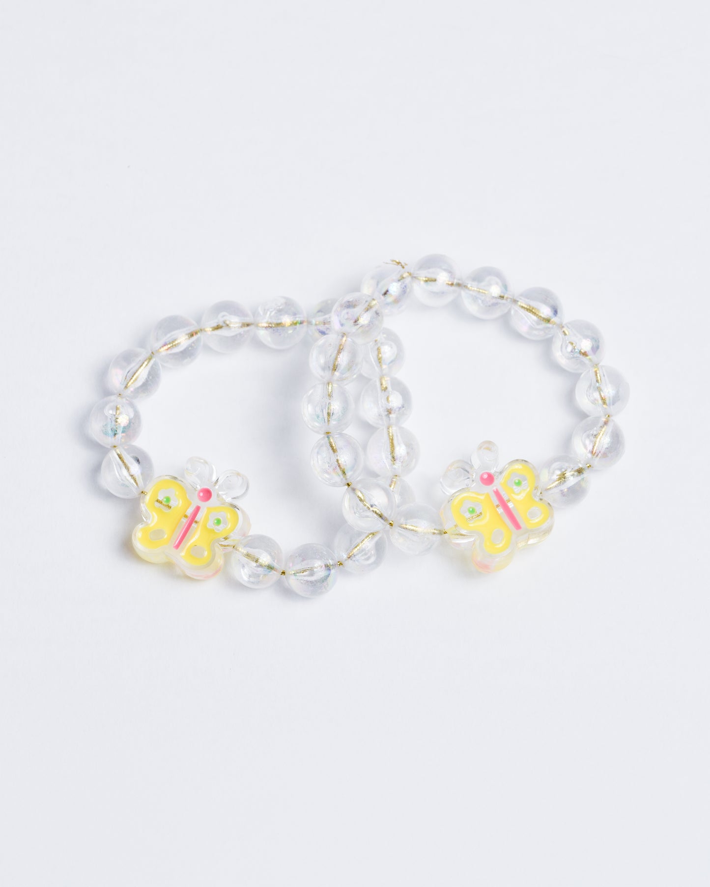 Transparent, shimmering plastic beads combined with a thick plastic butterfly holder, all attached to a very elastic and strong nylon cord that bends and stretches easily.