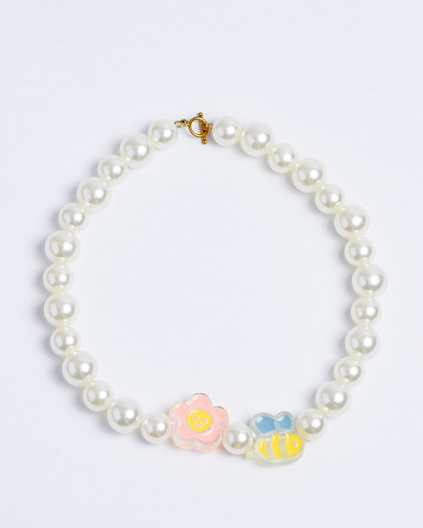 Large plastic pearls on a nylon cord with gold copper closures. Flower and bee beads dominate the design.