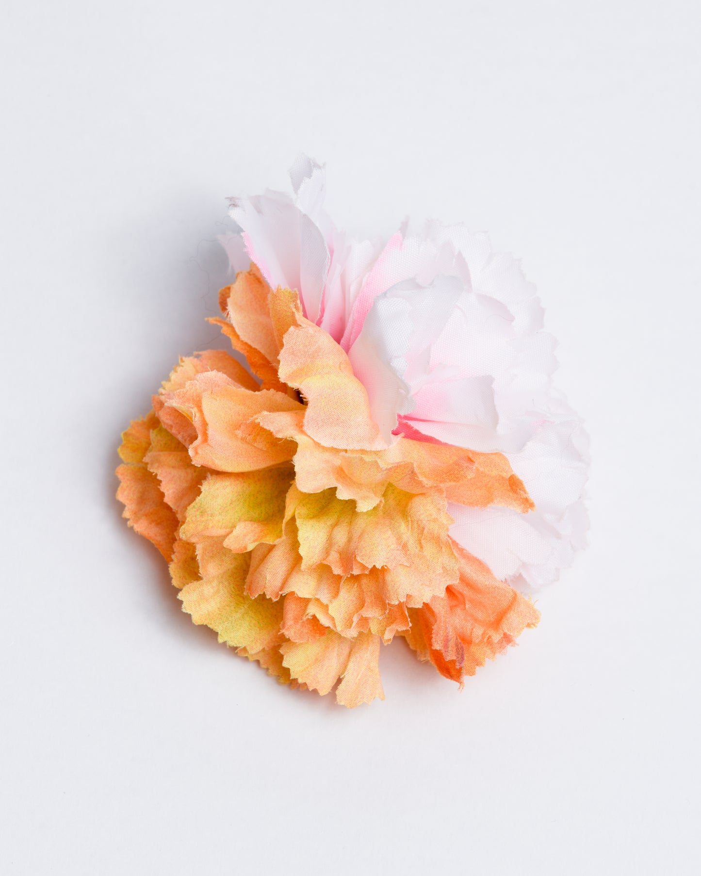 Two different types of synthetic flowers attached to a pin/clip