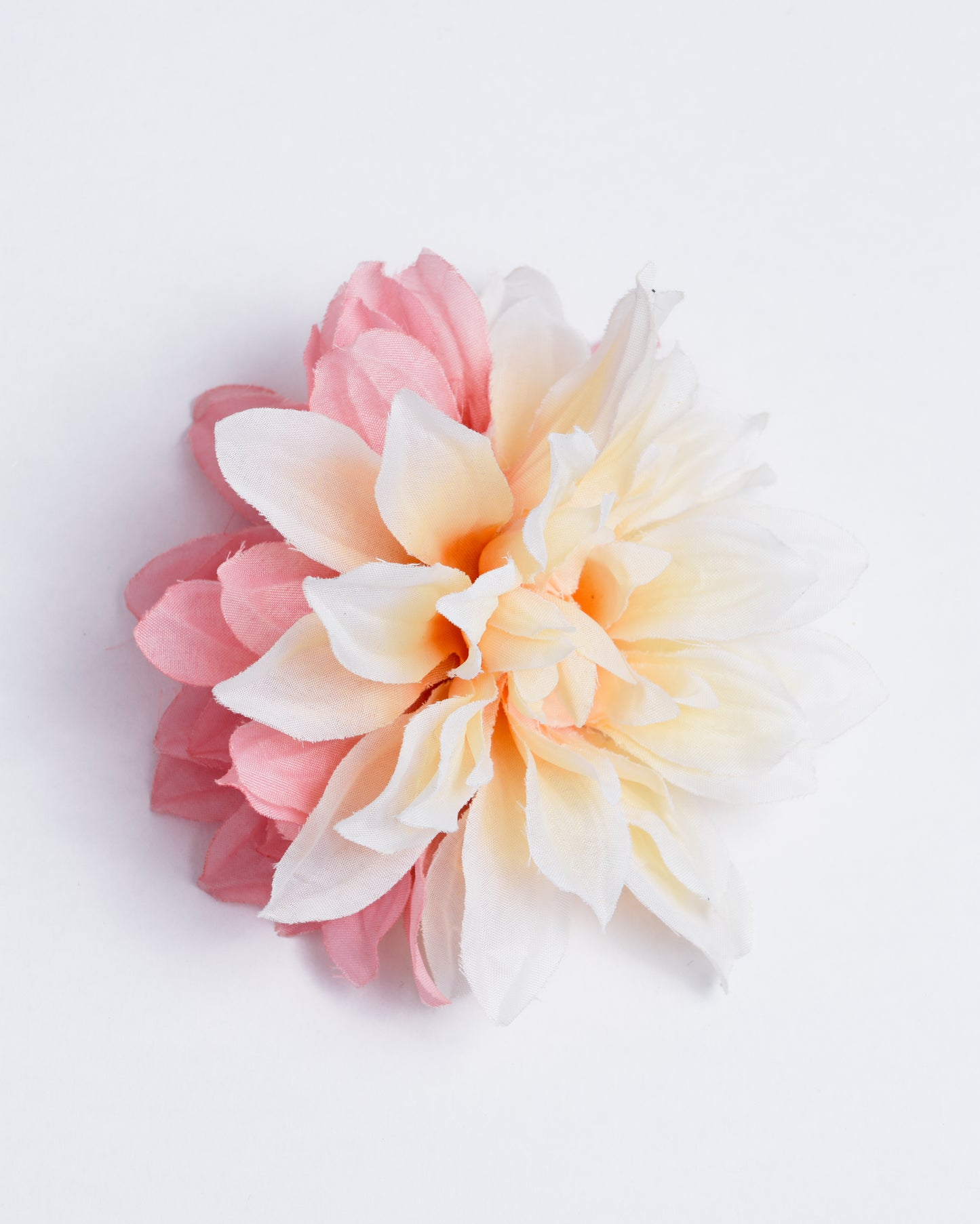 Two different types of synthetic flowers attached to a pin/clip