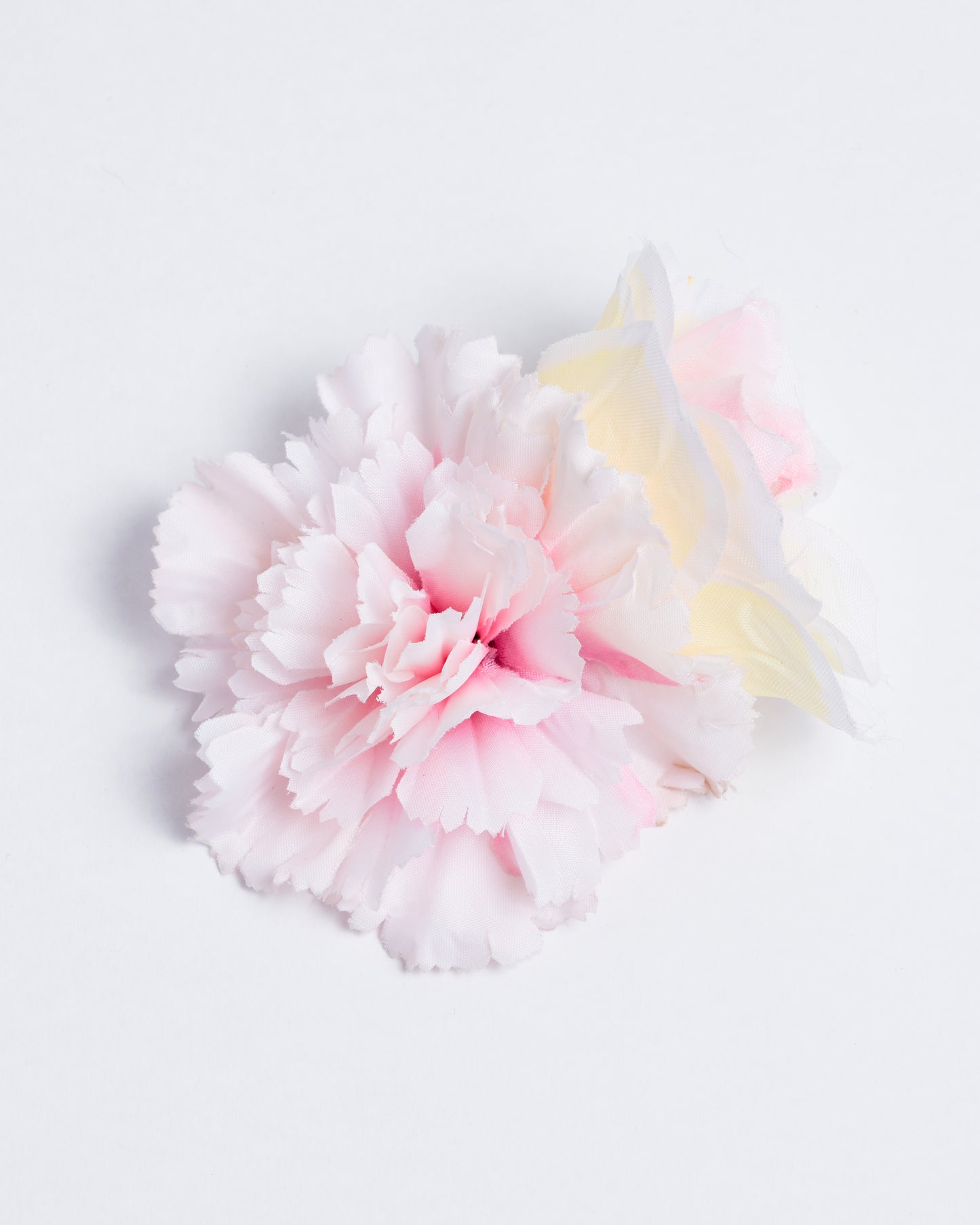 Two different types of synthetic flowers attached to a pin/clip
