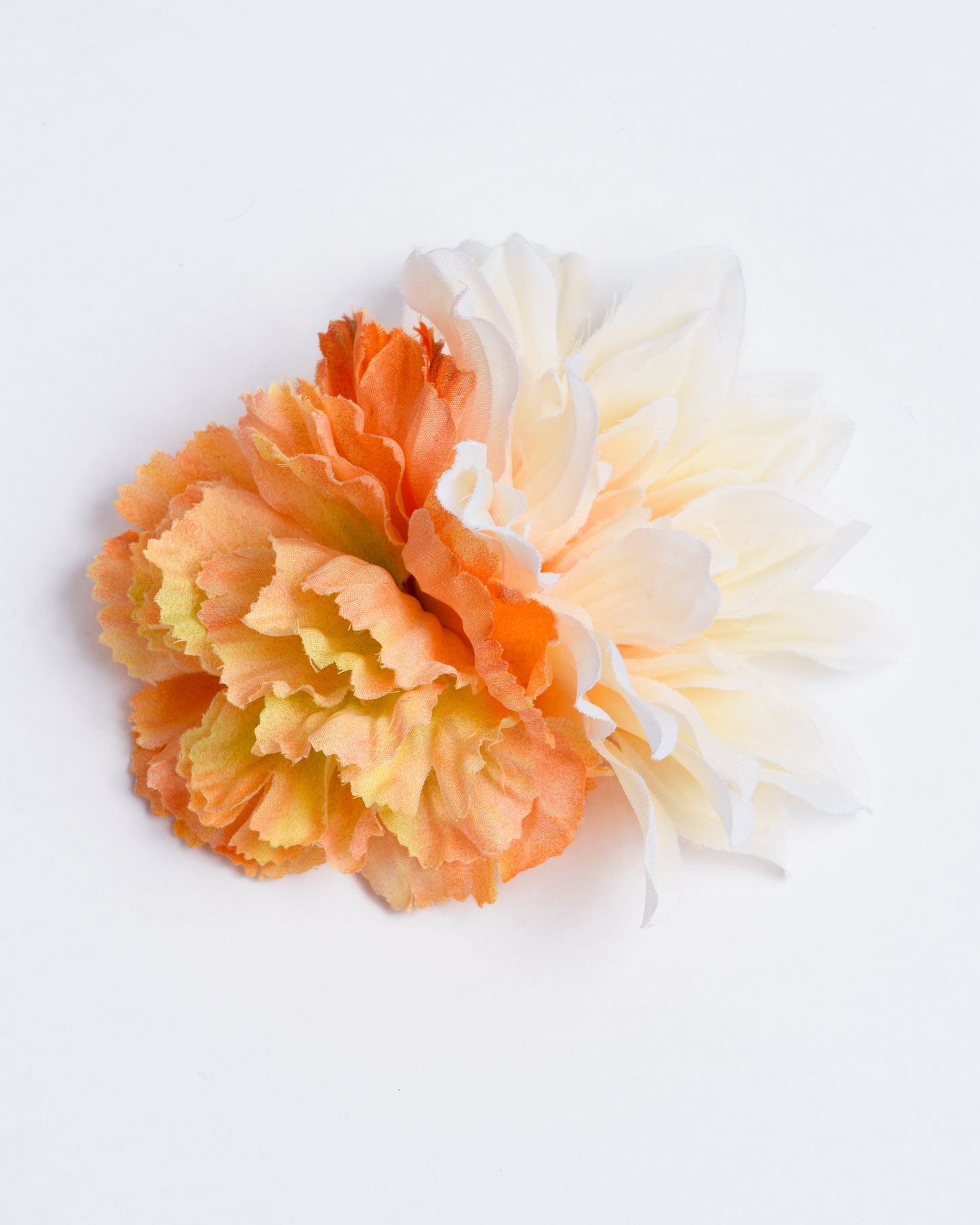 Two different types of synthetic flowers attached to a pin/clip
