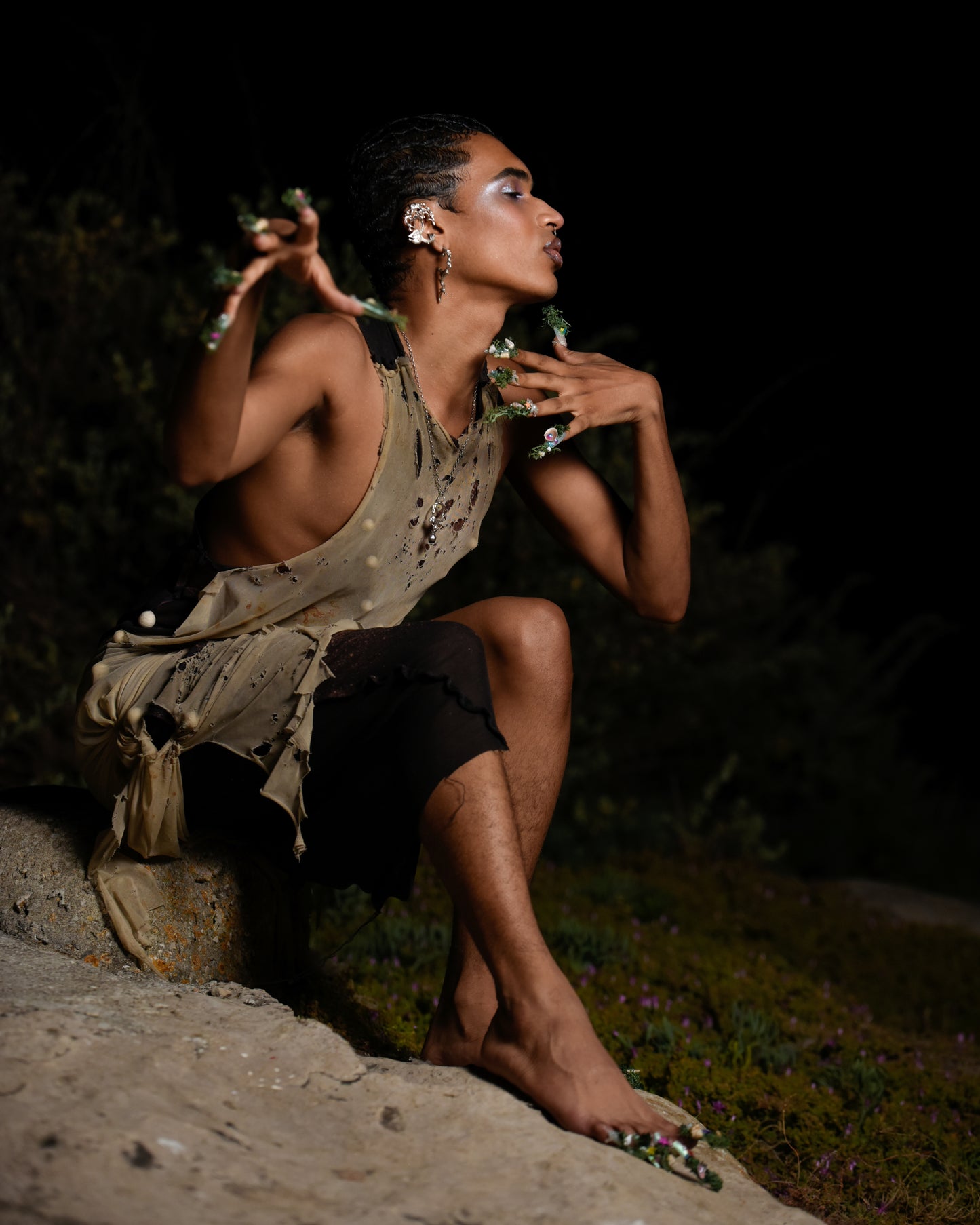 Model sitting on rock wearing kelp oasis nails