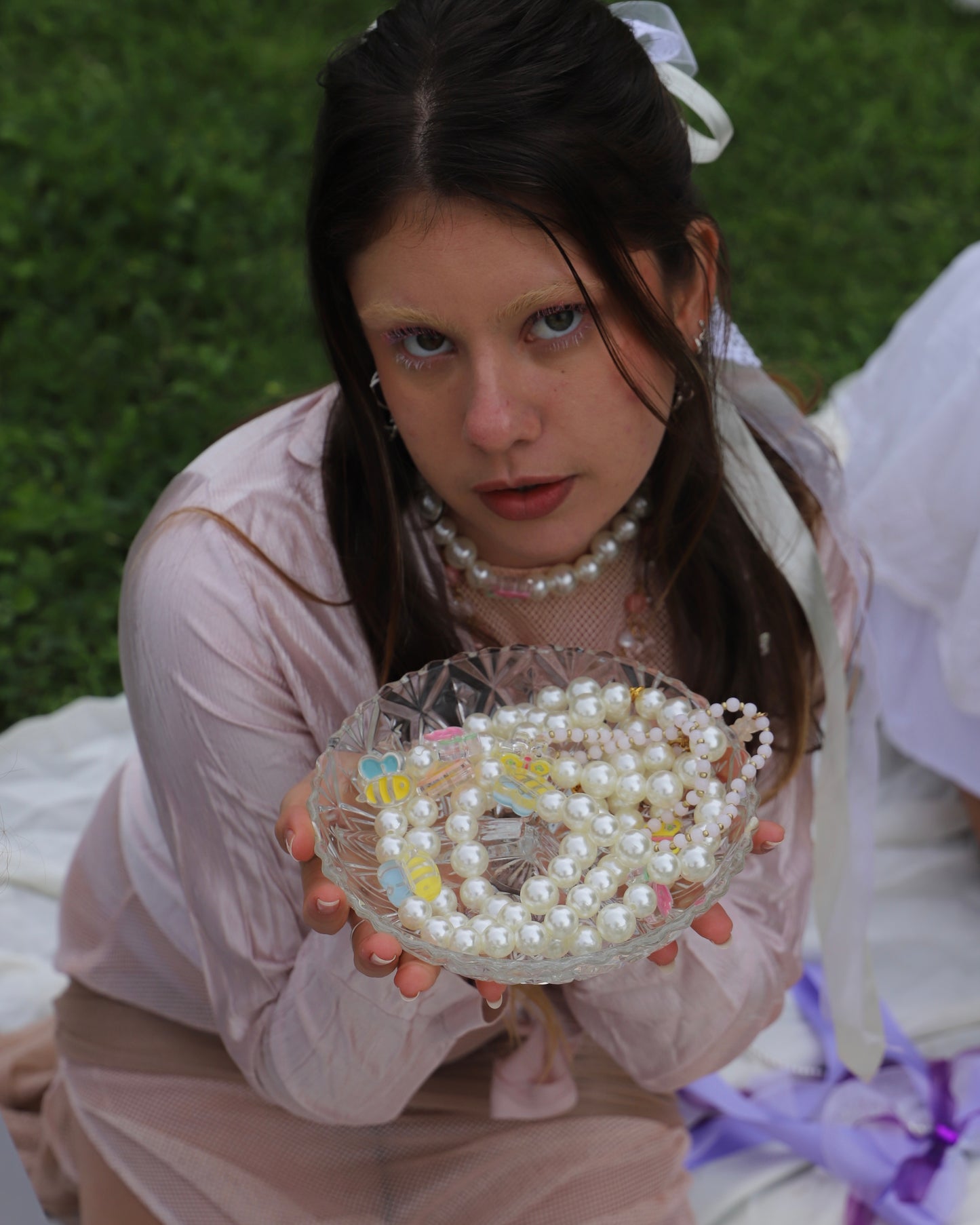 model holding various bee and tulip necklaces