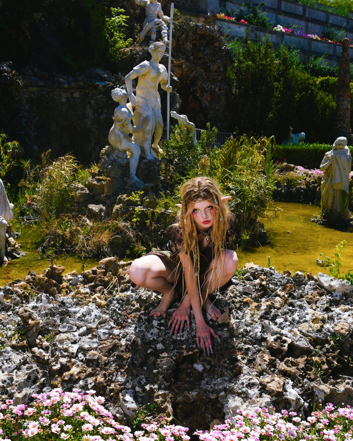 model sits on stones surrounded by green water wearing tidecaller necklace