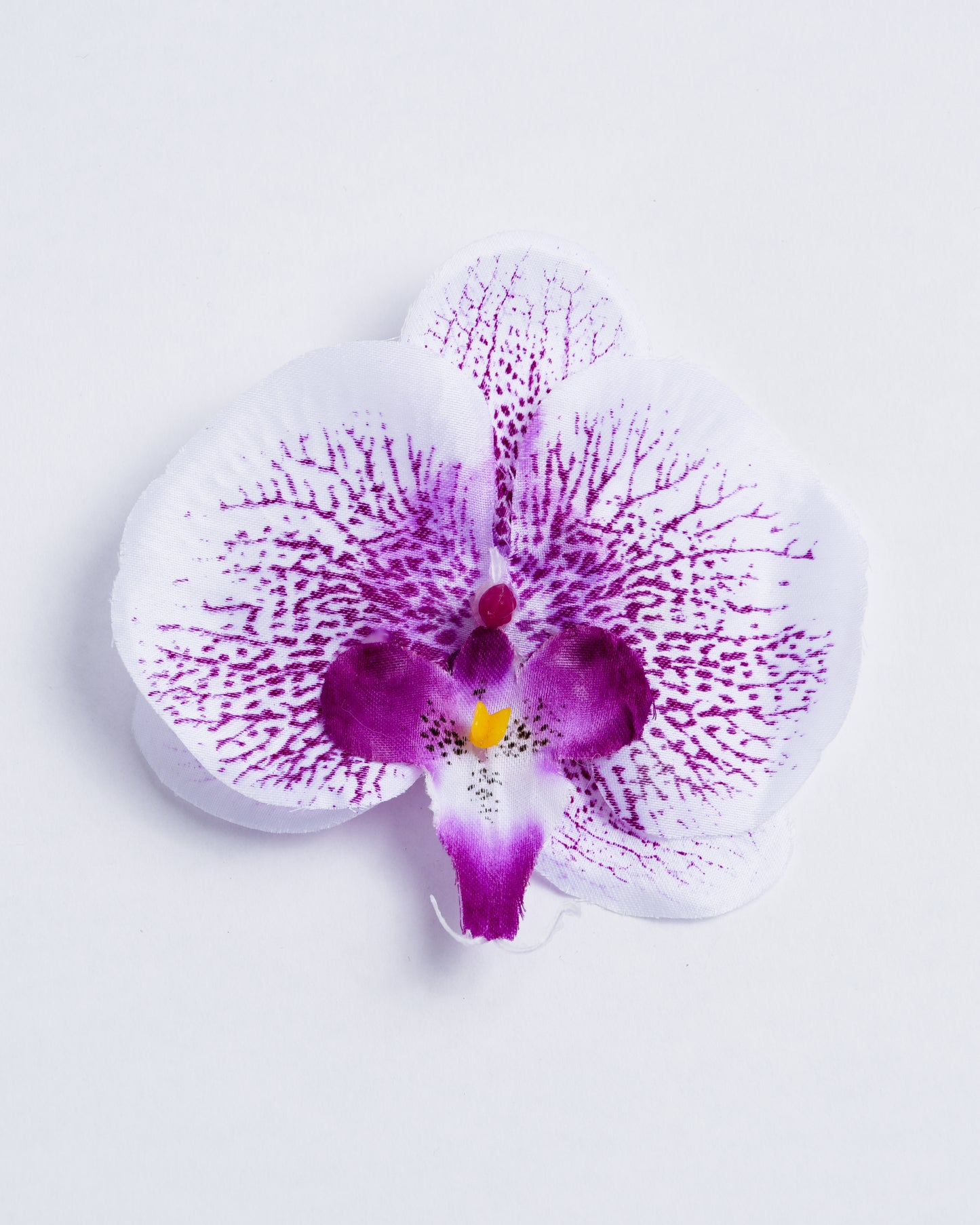 front of white and purple dotted fabric orchid flower