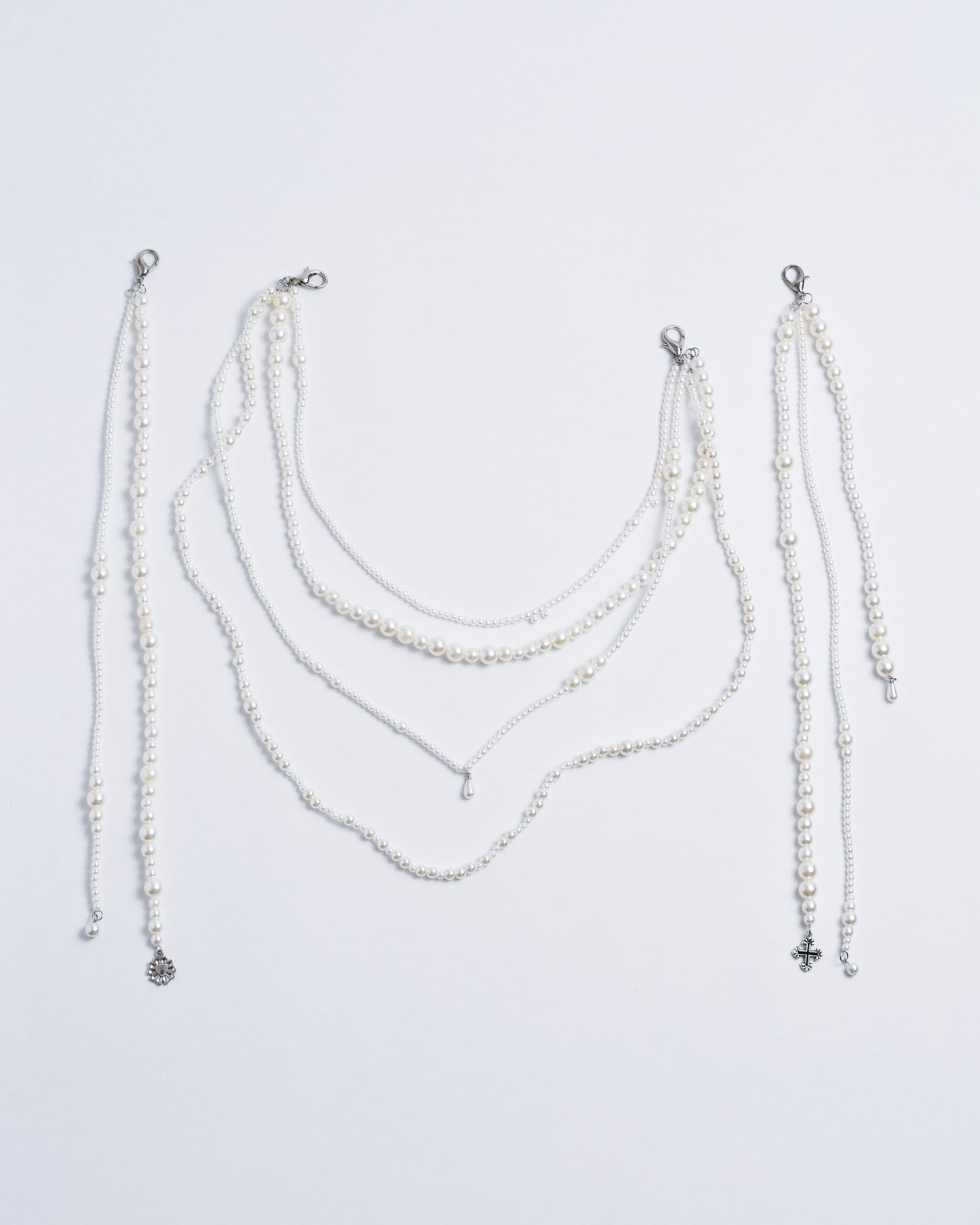Plastic pearls strung together on a nylon cord, with silver copper closures and pendants.