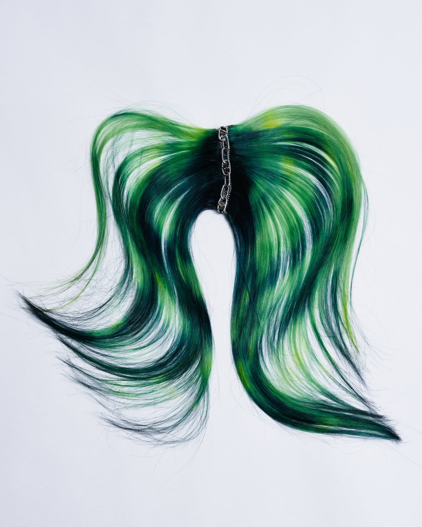 dark green hair extensions with light green and yellow highlights the extensions are sewed together with chains and metal spikes. On the inside it’s 6 clips to attach the hairpiece on the hair