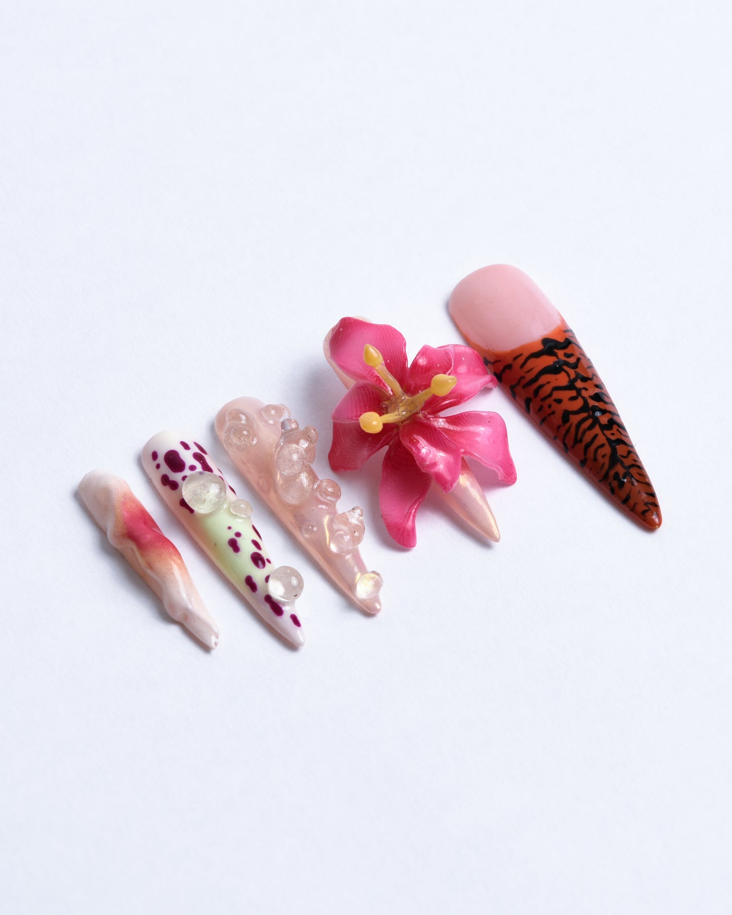 side view of XXL stiletto nails with hand sculpted pink flower orchid & orange black tiger patterns and 3D water drops