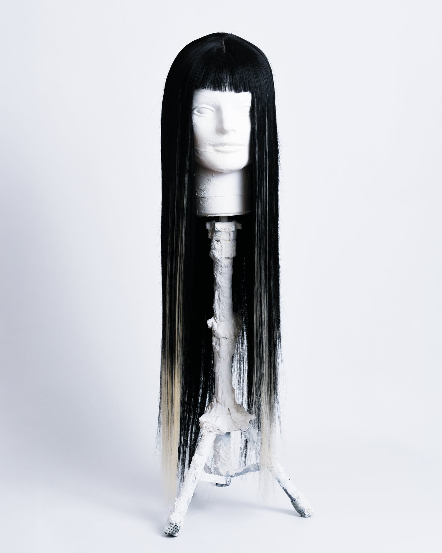 front of wig Alter is a 80cm long synthetic black wig with blonde highlights and short black bangs