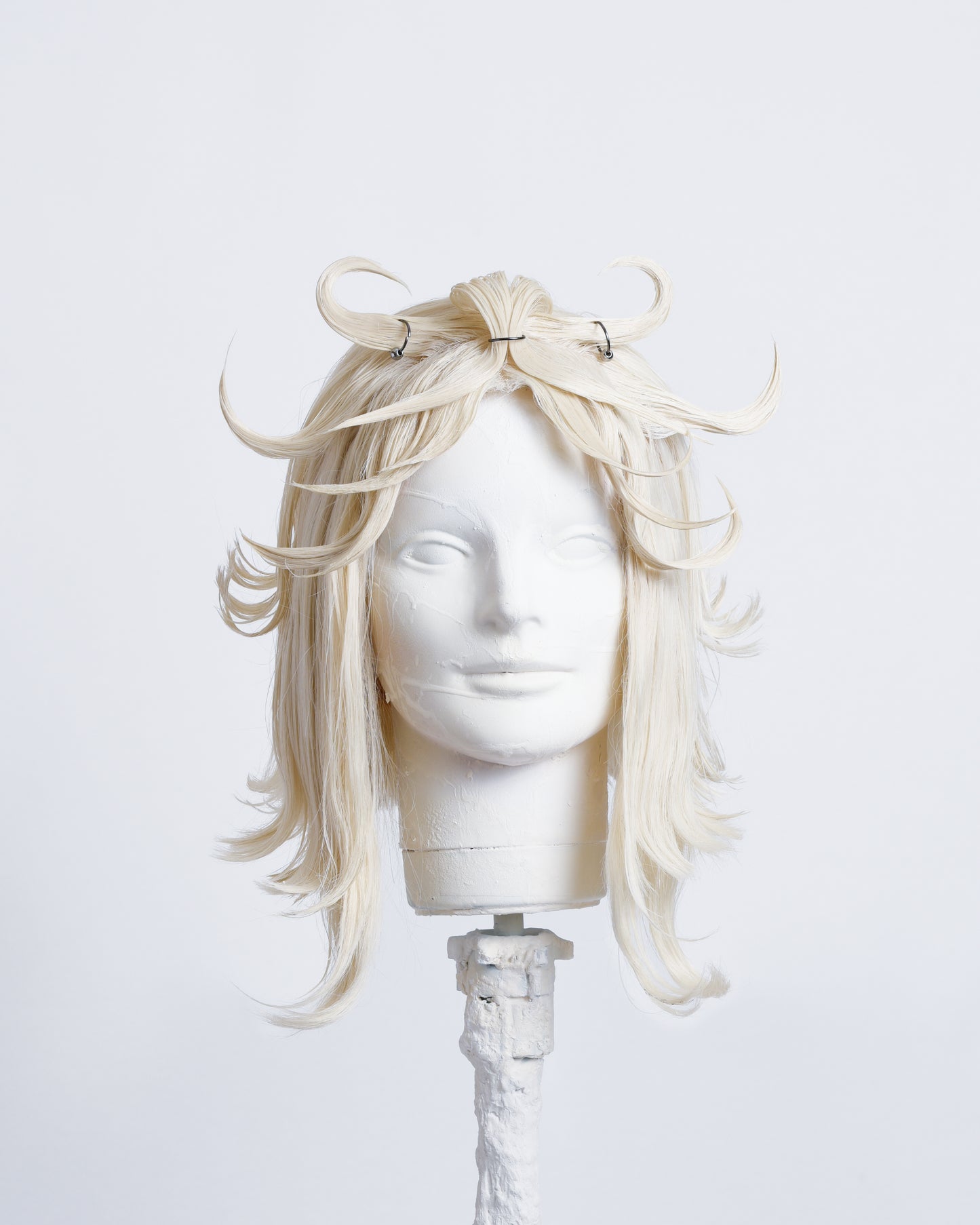 front of white 30cm long bob cut wig with styled spikes in the fringe inspired by a flower , highlighted with metal rings .